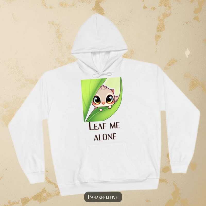 Funny hoodie with a cute, wide-eyed winged creature playfully peeking from behind a large green leaf. Cozy and humorous apparel.