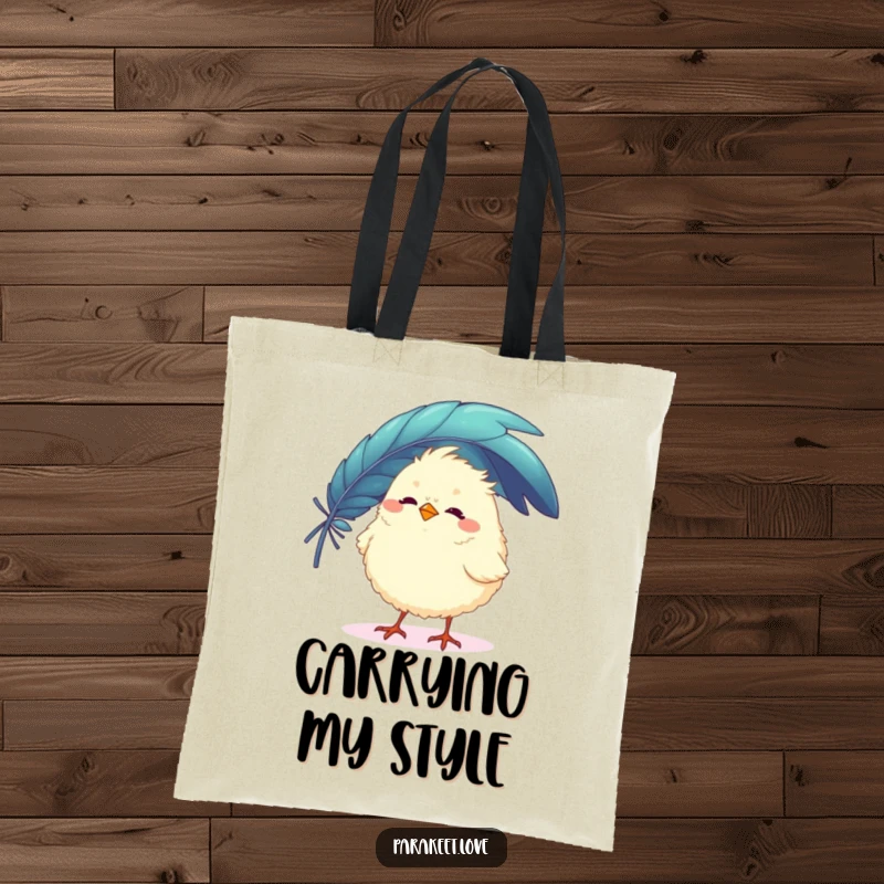 Funny tote bag featuring a fluffy, round bird character playfully balancing a large, colorful feather on its beak. Stylish and humorous.